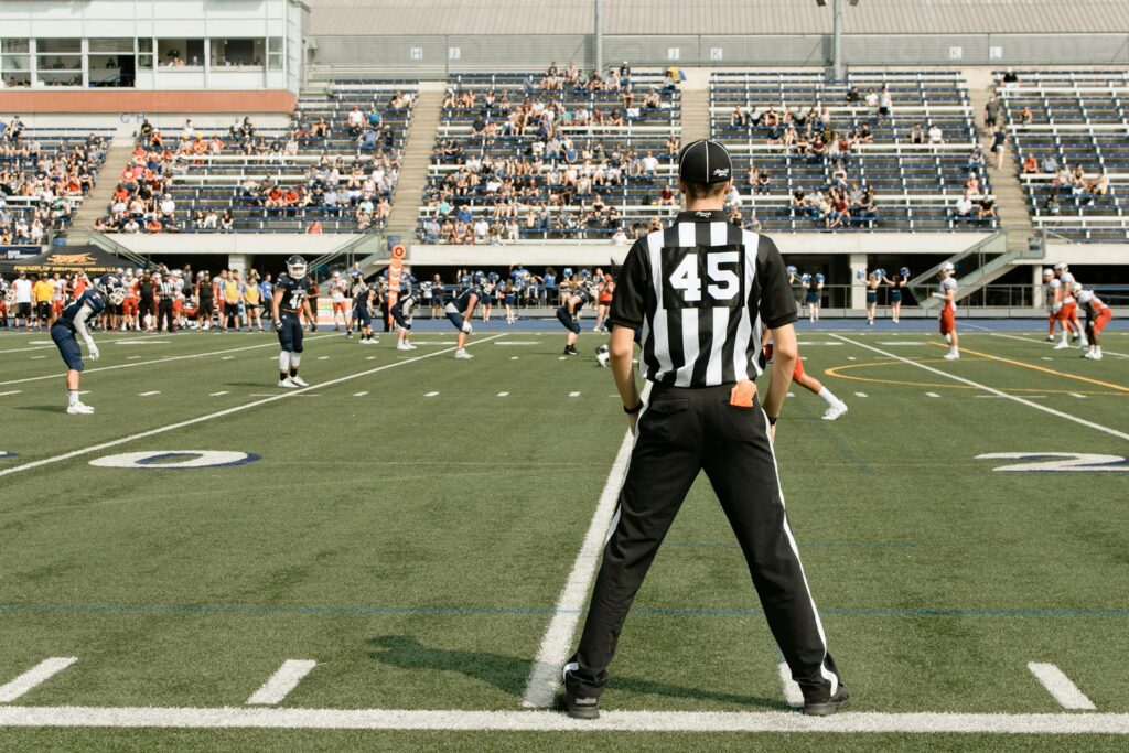 American football game with referee and players in action at a stadium in Toronto, Canada.
